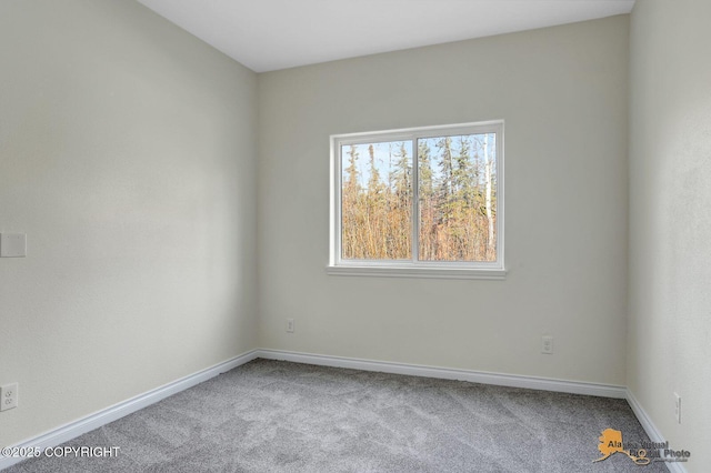 carpeted empty room featuring baseboards