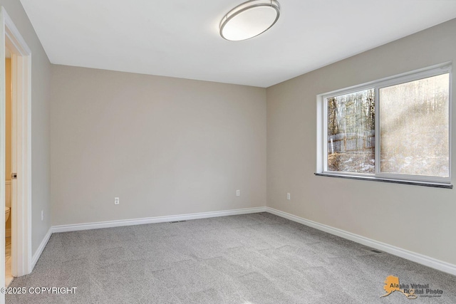 carpeted empty room featuring baseboards