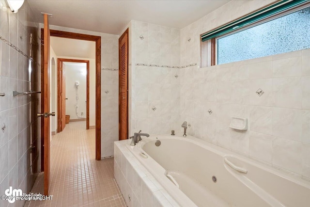 full bathroom with a garden tub, tile walls, and tile patterned flooring