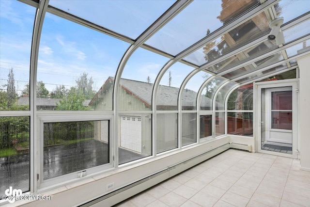 unfurnished sunroom featuring a baseboard heating unit and lofted ceiling