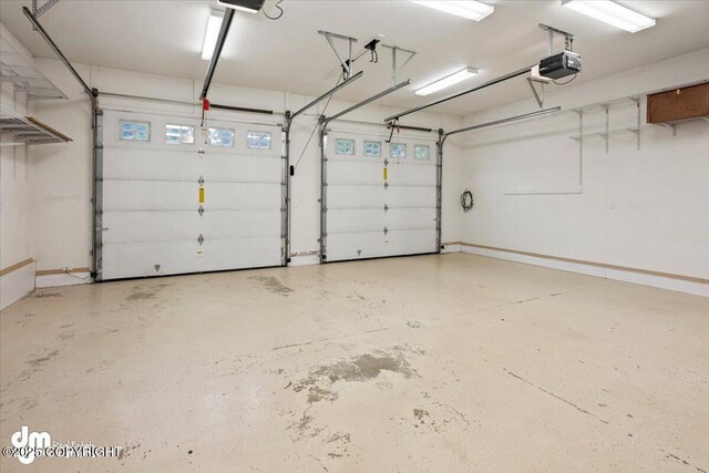 garage featuring a garage door opener and baseboards