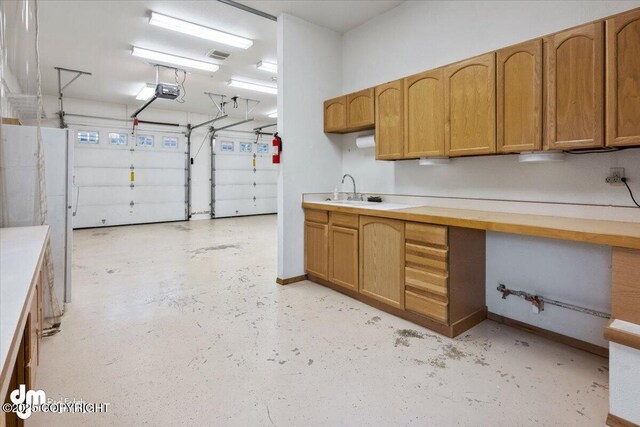 garage featuring baseboards and a sink