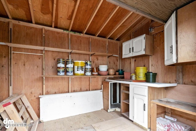 kitchen with white cabinetry, light countertops, lofted ceiling, and open shelves