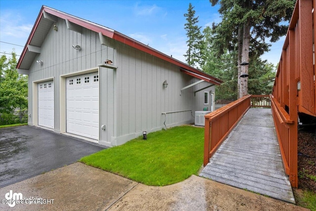 view of property exterior featuring a yard, central AC unit, a garage, and a wooden deck