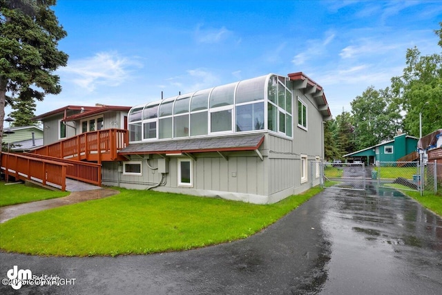 exterior space with a front yard, a gate, fence, and aphalt driveway