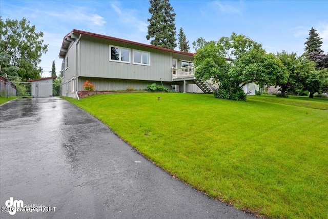 view of front of home with stairs, a front lawn, and driveway