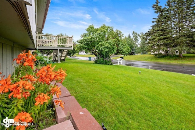 view of yard featuring stairs and a wooden deck