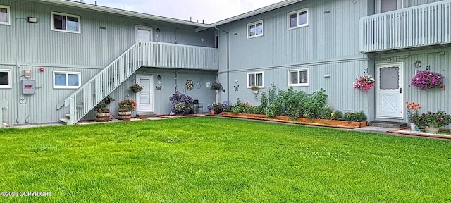 back of property featuring a yard and stairway