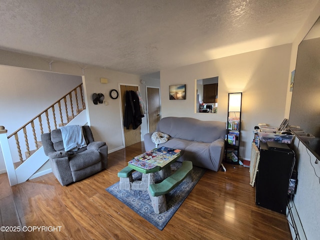 408 Haller St, Kenai, AK 99611 - living area with a textured ceiling, wood finished floors, stairs, a baseboard radiator, and baseboards