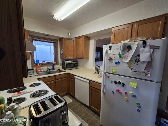 408 Haller St, Kenai, AK 99611 - kitchen with white appliances, a sink, light countertops, brown cabinets, and ventilation hood