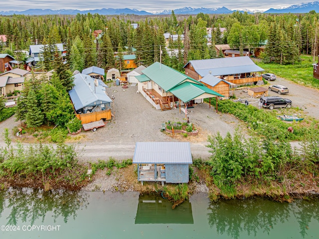 birds eye view of property with a water and mountain view and a view of trees