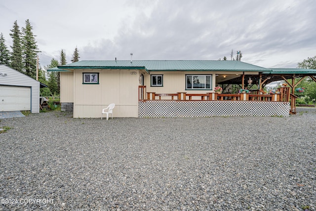 back of property featuring metal roof and an outdoor structure