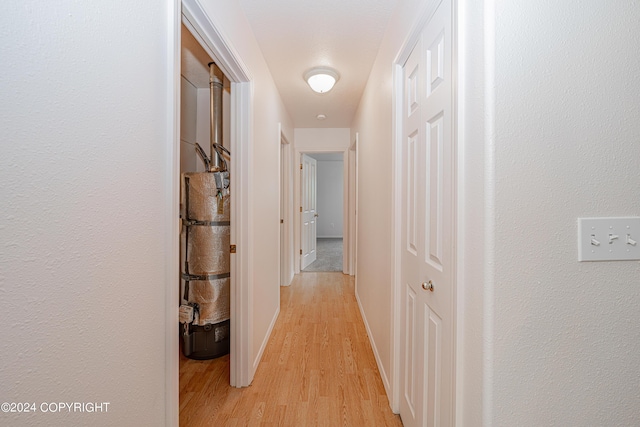 hallway with light wood-type flooring and baseboards