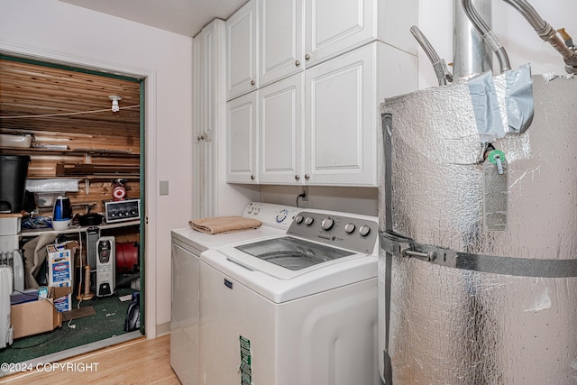 laundry room featuring light wood-type flooring, cabinet space, and washer and dryer