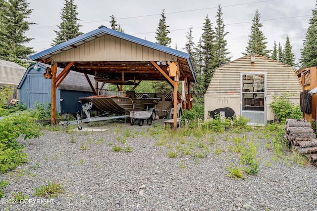 exterior space with driveway, a storage unit, and a detached carport