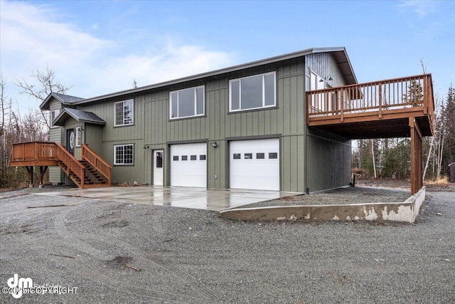 view of front of property with a deck, driveway, stairway, and a garage