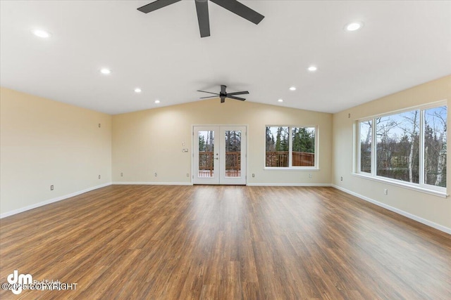 unfurnished living room featuring lofted ceiling, baseboards, wood finished floors, and french doors