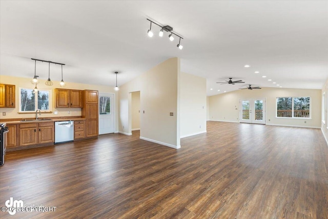 unfurnished living room with vaulted ceiling, dark wood-type flooring, a sink, and baseboards