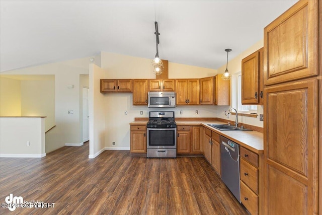 kitchen featuring brown cabinets, dark wood finished floors, light countertops, appliances with stainless steel finishes, and a sink