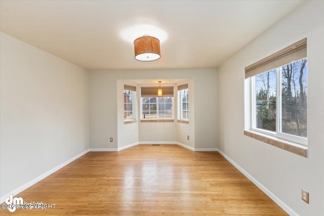 empty room with baseboards and light wood finished floors