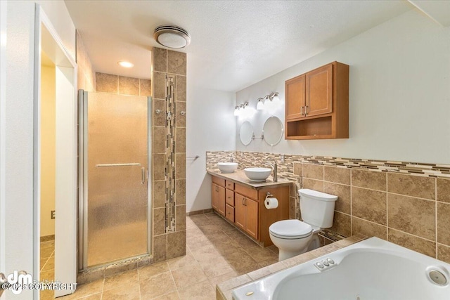 bathroom featuring toilet, a shower stall, a tub with jets, and tile walls