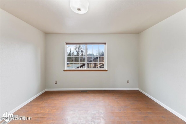 empty room featuring wood finished floors and baseboards