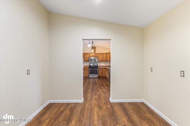 interior space with lofted ceiling, dark wood-type flooring, and baseboards