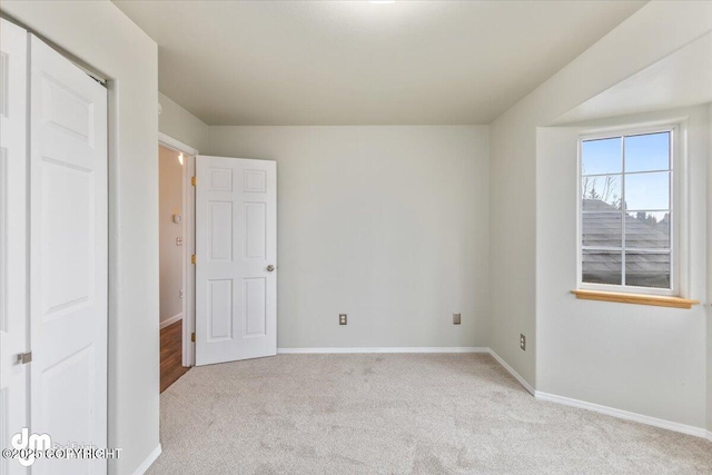 unfurnished bedroom with baseboards and light colored carpet