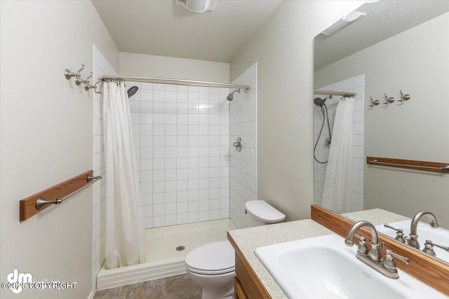 full bathroom with a stall shower, vanity, and toilet