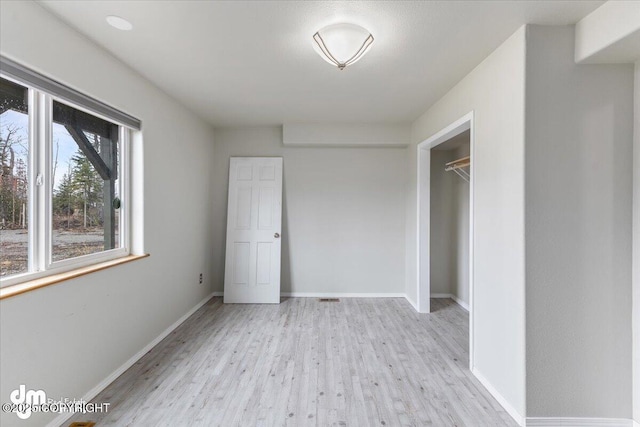 unfurnished bedroom with a closet, baseboards, and wood finished floors