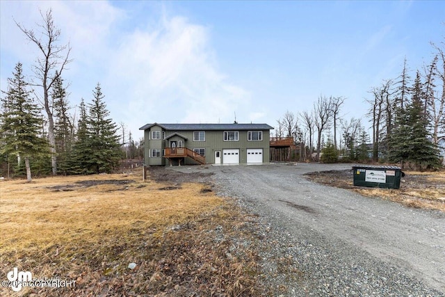 view of front of home with a garage and gravel driveway