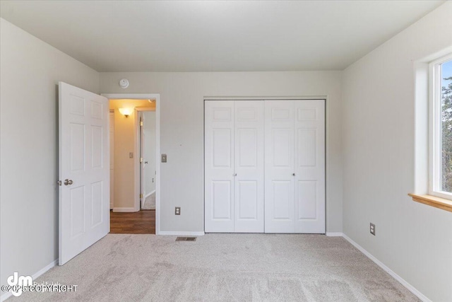 unfurnished bedroom featuring carpet floors, a closet, and baseboards