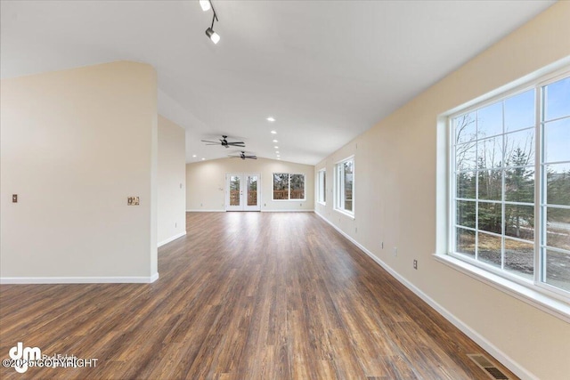 unfurnished living room with a healthy amount of sunlight, visible vents, vaulted ceiling, and wood finished floors