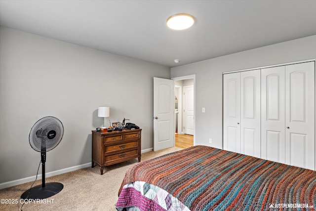 bedroom with light carpet, a closet, and baseboards