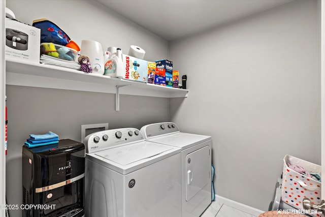 clothes washing area featuring laundry area, baseboards, and washer and clothes dryer