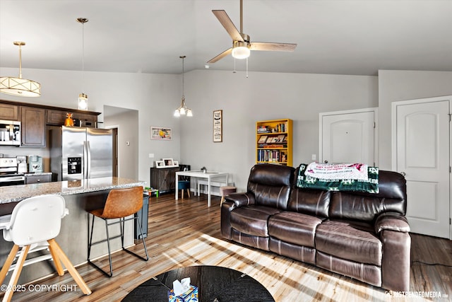 living area with light wood-type flooring, vaulted ceiling, and a ceiling fan