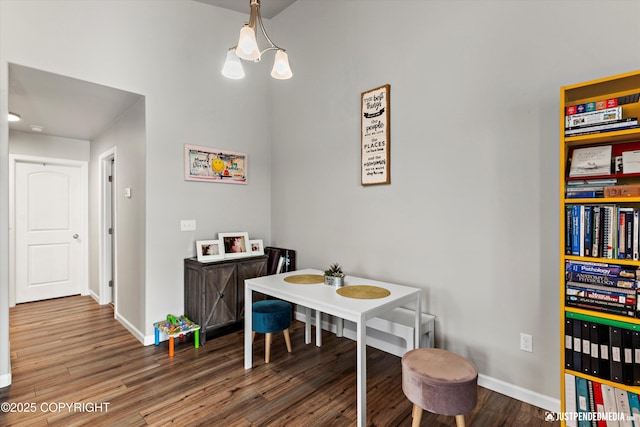 dining area with a notable chandelier, baseboards, and wood finished floors