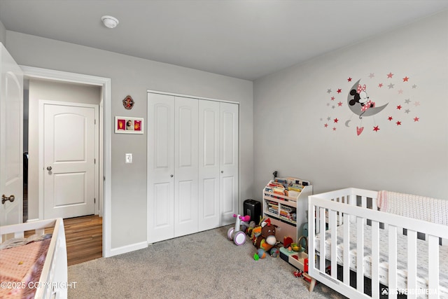 carpeted bedroom with baseboards and a closet