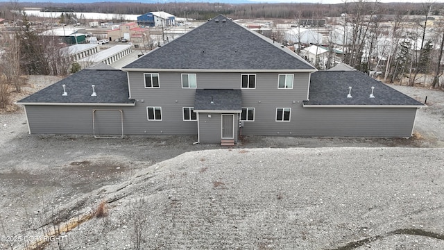 back of house featuring a shingled roof