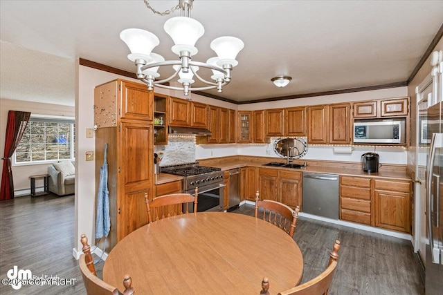 kitchen with a sink, a baseboard heating unit, under cabinet range hood, dark wood-style floors, and stainless steel appliances