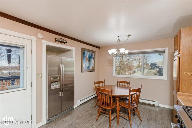 dining room featuring a chandelier, wood finished floors, baseboards, and a baseboard radiator