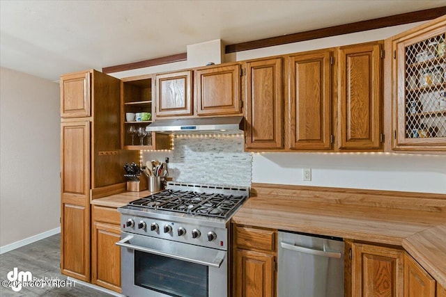 kitchen featuring brown cabinets, under cabinet range hood, tasteful backsplash, stainless steel appliances, and baseboards