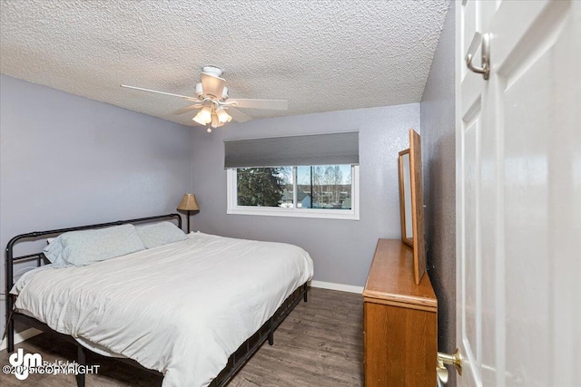 bedroom featuring baseboards, a textured ceiling, wood finished floors, and a ceiling fan