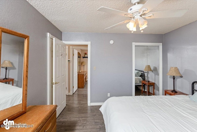 bedroom with ceiling fan, baseboards, wood finished floors, a closet, and a textured ceiling