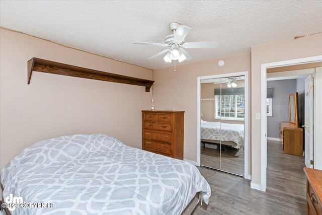 bedroom with baseboards, wood finished floors, a closet, a textured ceiling, and a ceiling fan