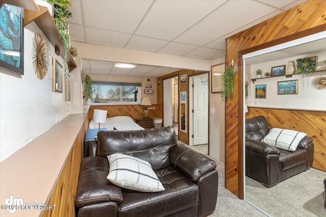 bedroom with wooden walls, carpet flooring, and a drop ceiling