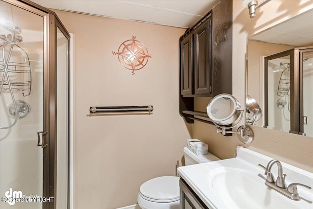 full bathroom with vanity, a shower stall, and toilet