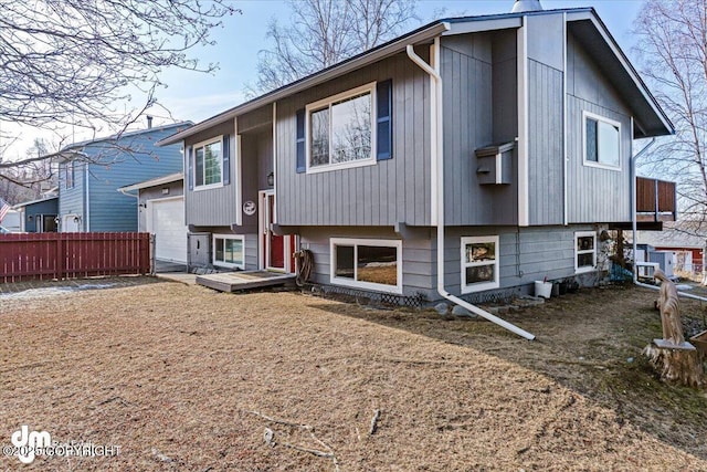 back of house with a garage and fence