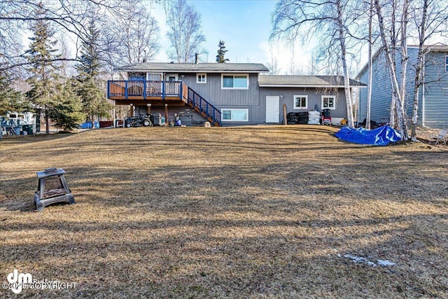 back of property with stairway, a lawn, and a deck