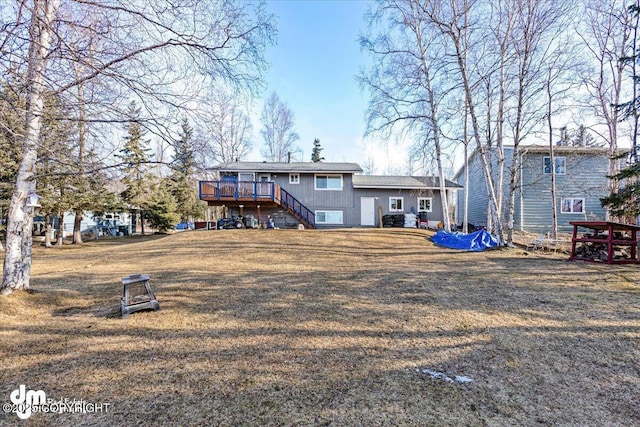 back of property with stairs, a yard, and a wooden deck